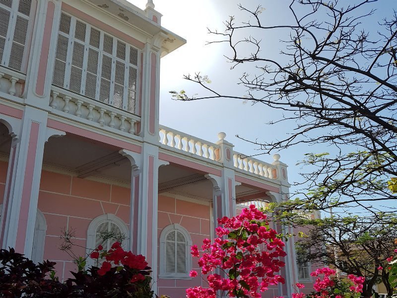 Pink colonial palace in Mindelo with red bougainvillea in front
