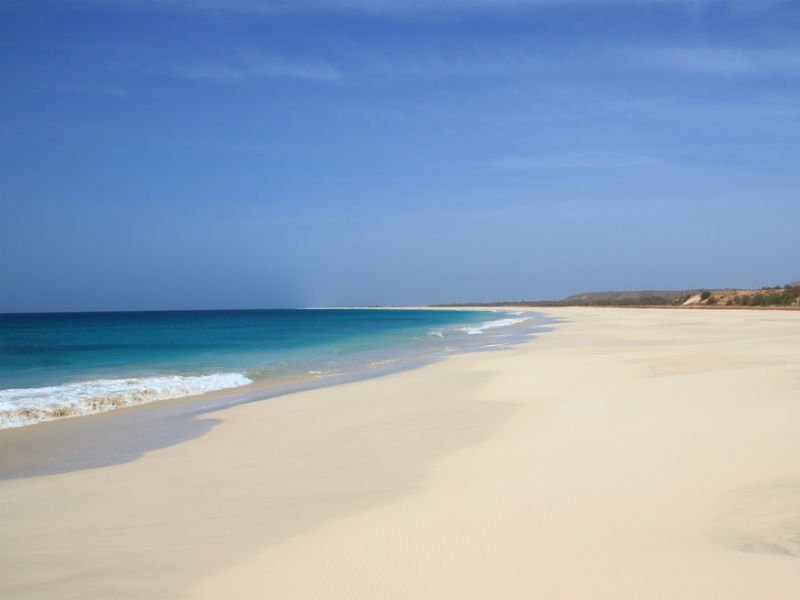 White sandy beach with a calm turquoise sea under a blue sky